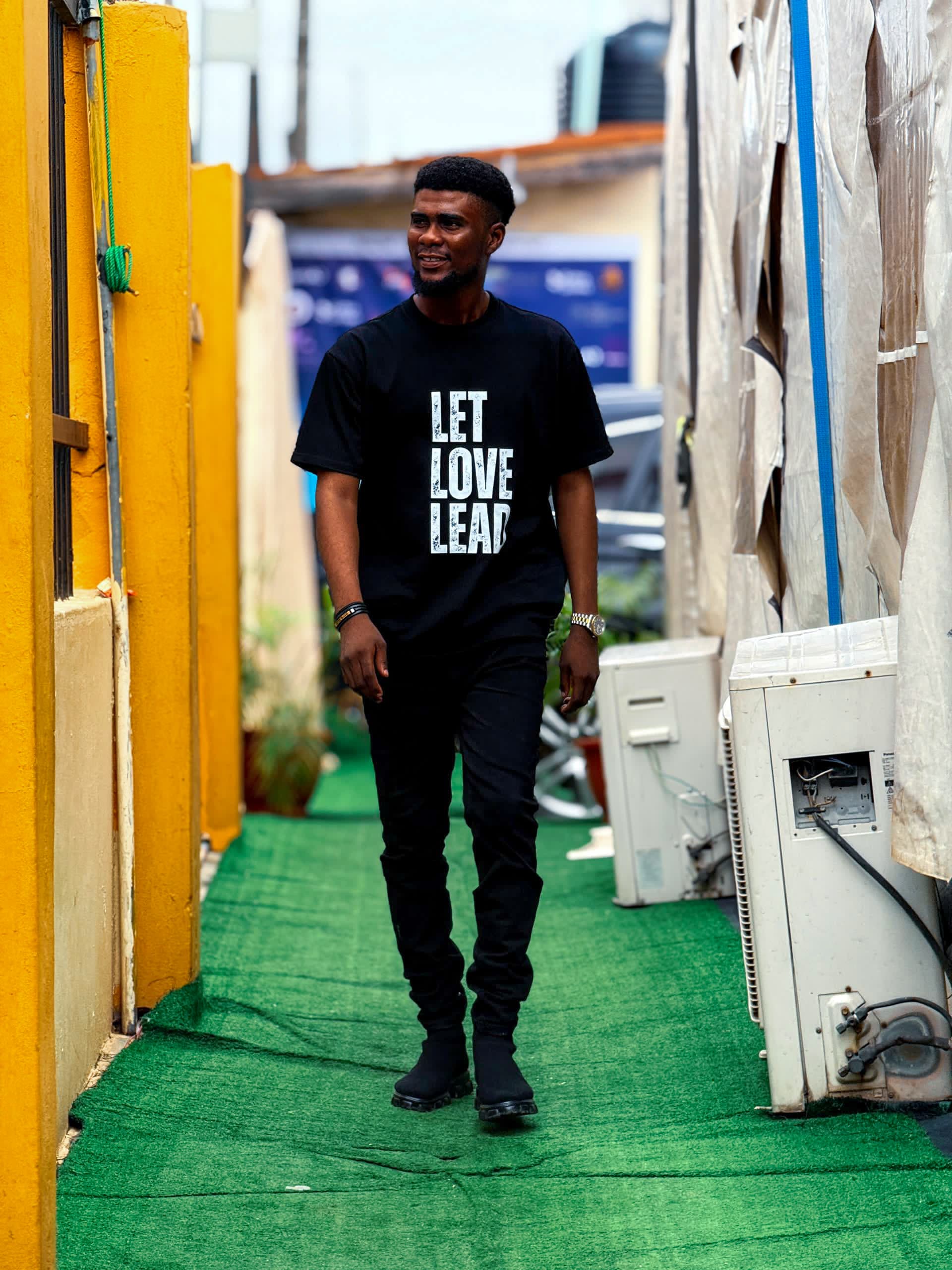 Pastor Emmanuel Atufe walking in Let Love Lead ministry shirt
